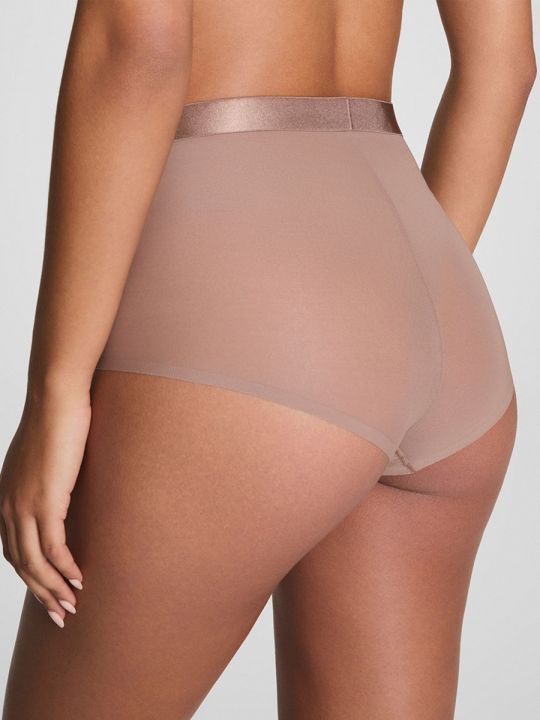 Modelo con braga faja Spanx Sheer Smoothing en color tostado, vista de espalda.