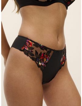 Tanga brasileña Fantasie Magdalena en Noir, vista frontal y lateral sobre modelo mostrando bordado multicolor y panel opaco.